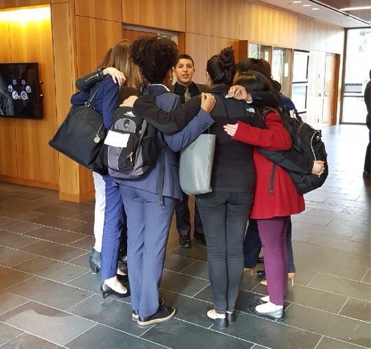 The 2017 - 2018 LaLSA Moot Court Team huddled in a hallway at UC Davis School of Law