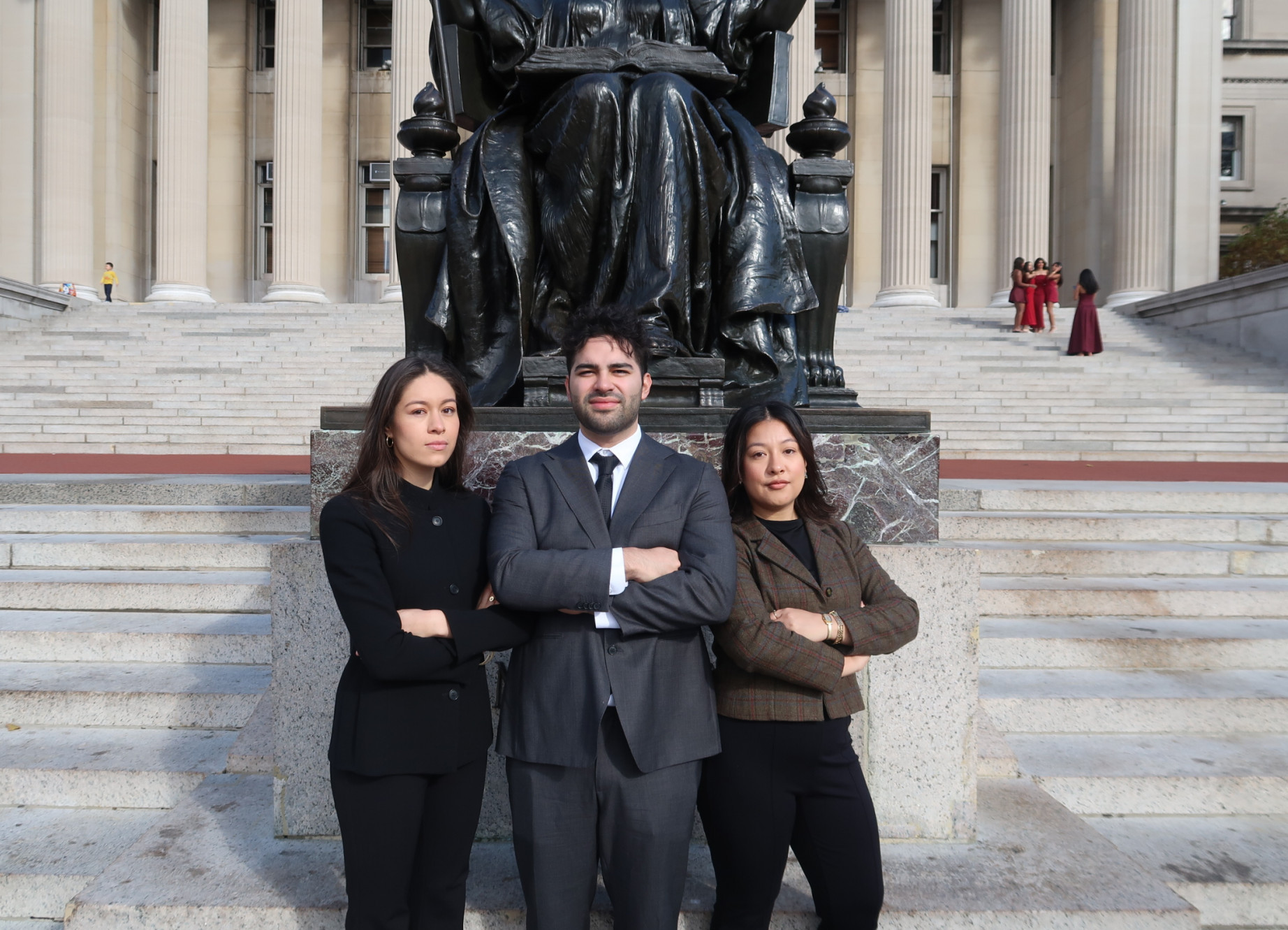Three students in front of statute
